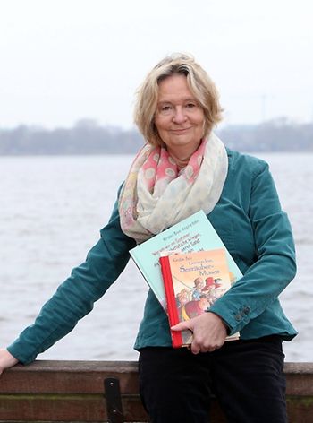 Die Kinder- und Jugendbuchautorin Kirsten Boie mit zwei ihrer Veröffentlichungen vor dem Hamburger Alsterpanorama.