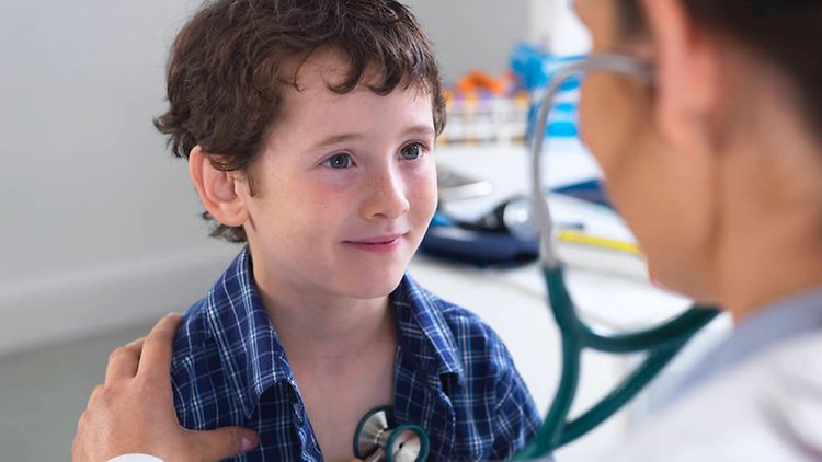  Ein Kind wird von einem Arzt abgehorcht.