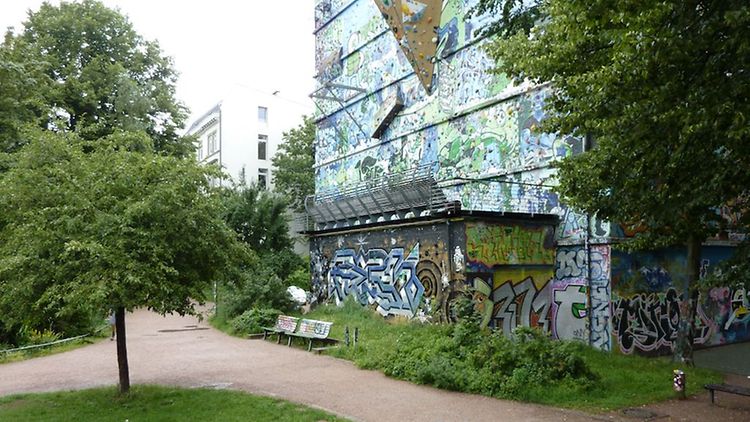  Ein Gebäude, welches mit Graffiti besprüht wurde, in einem Park.