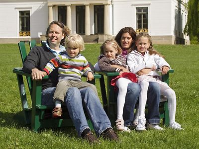  Eine Familie sitzt auf grünen Holzstühlen im Jenischpark