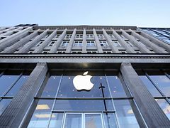  An einer Glasfassade hängt das Symbol eines Apfels, der angebissen ist. Der Apfel ist weiß und gehört zu Apple-Store.