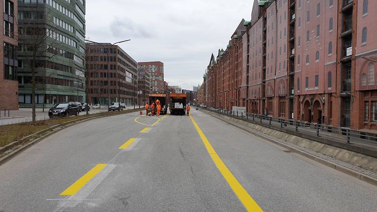  Bauarbeiten ziehen für die neue Pop-Up-Bikelane in der HafenCity gelbe Linien auf den Sandtorkai