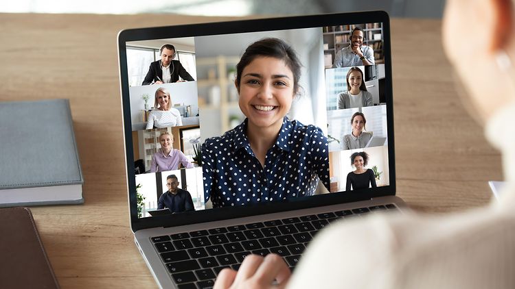  Aufgeklappter Desktop zeigt sieben Personen in einer Online-Besprechung