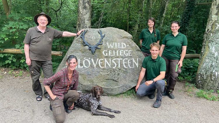  Das Team des Wildgehege Klövensteen mit der Waldschule gruppiert sich um einen Stein mit Inschrift Wildgehege Klövensteen