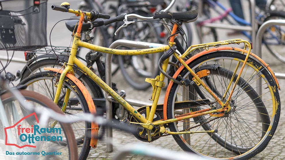 Mehrere Fahrräder stehen an Fahrradständern. Links unten am Bildrand steht freiRaum Ottensen - Das autoarme Quartier.