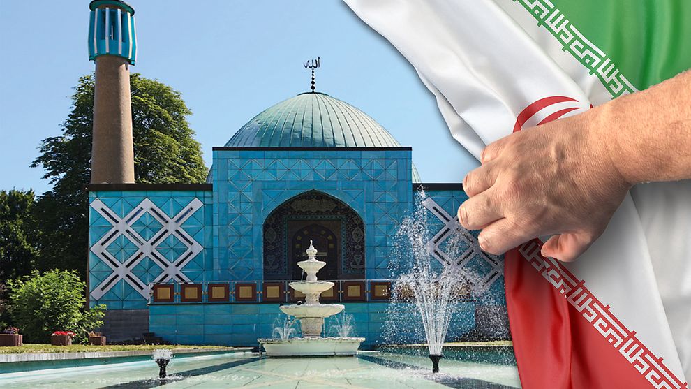 Abbildung der "Blauen Moschee" mit davor platzierter Iranischer Flagge die durch eine Hand wie ein Vorhang weggezogen wird.