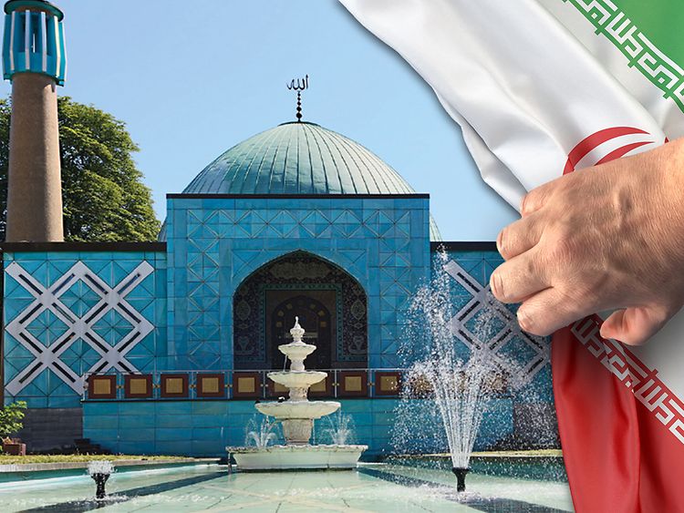  Abbildung der "Blauen Moschee" mit davor platzierter Iranischer Flagge die durch eine Hand wie ein Vorhang weggezogen wird.