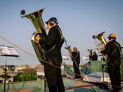  Vier Männer mit Blasinstrumenten stehen musizierend auf einem Dach in Hamburg.