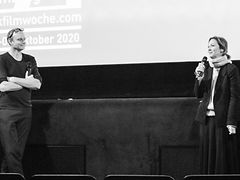  Felix Grimm und Ute Adamczewski stehen auf einer Bühne und führen ein Gespräch im Rahmen der dokumentarfilmwoche 2020.