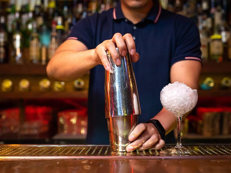  Ein Barkeeper bereitet einen Cocktail mit Eis zu.