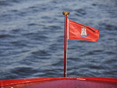  Eine rote Hamburg-Fahne vor Wasser