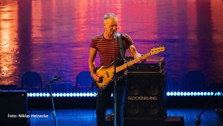 Musiker Sting steht auf der Bühne bei der Eröffnung des Reeperbahn Festivals 2021, spielt Gitarre und singt 