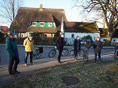  Fünf Personen stehen auf einem Fußweg, im Hintergrund ihre Fahrräder.