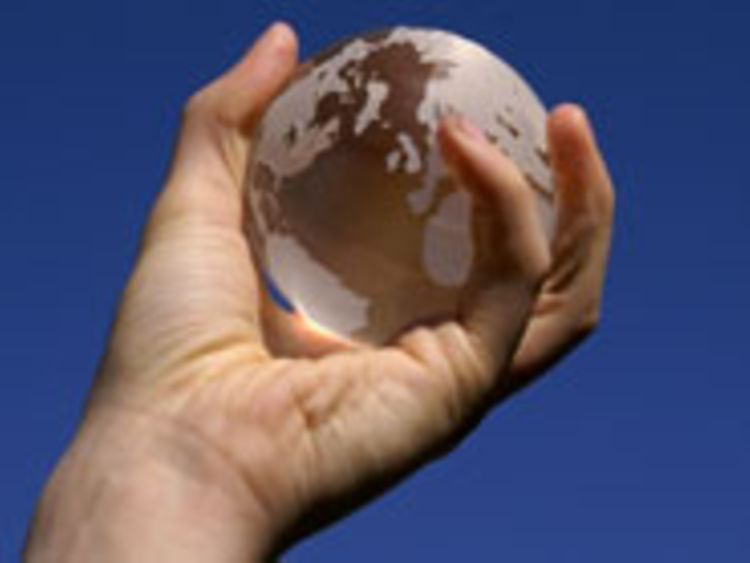  Hand hält einen gläsernen Globus vor blauem Himmel (Stephanie Hofschlaeger // www.pixelio.de)