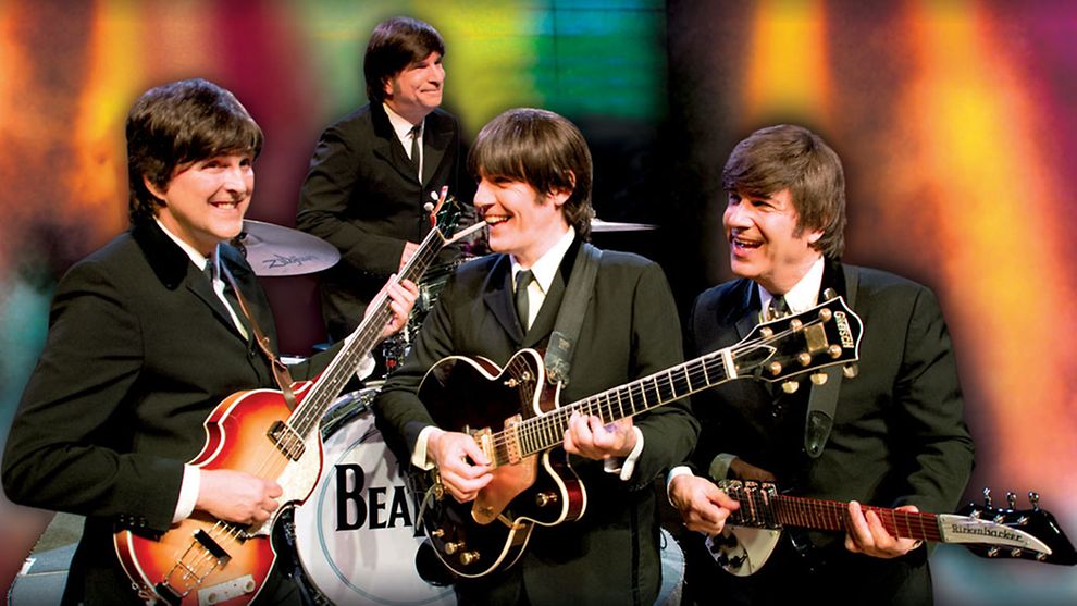  Die Beatles mit Instrumenten vor buntem Hintergrund.