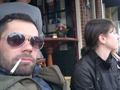  ein Mann mit Sonnenbrille und Bart und eine Frau im Halbprofil mit schwarzer Jacke