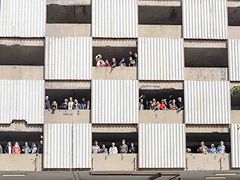  Menschen schauen aus einem Gebäude.