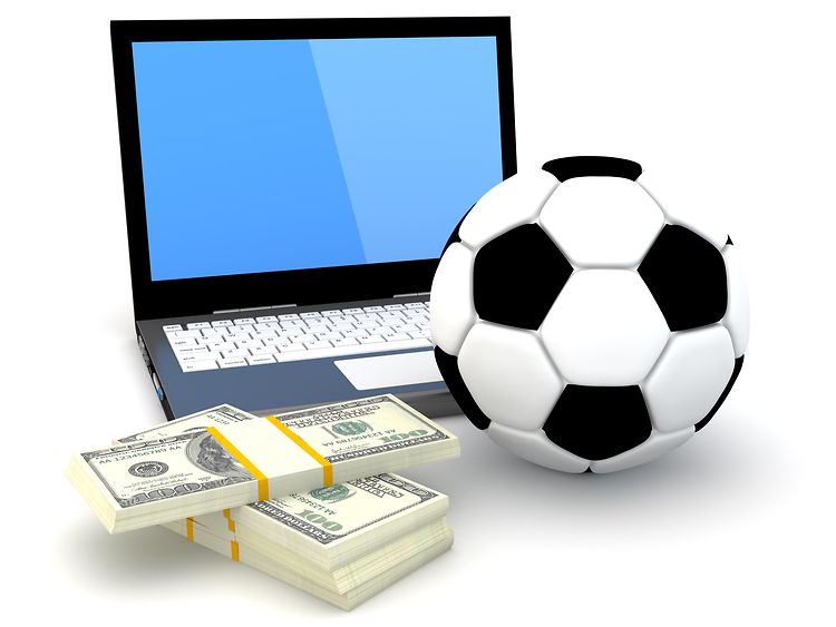  Aufgeklappter Laptop, davor ein Fußball und ein Bündel Geldscheine