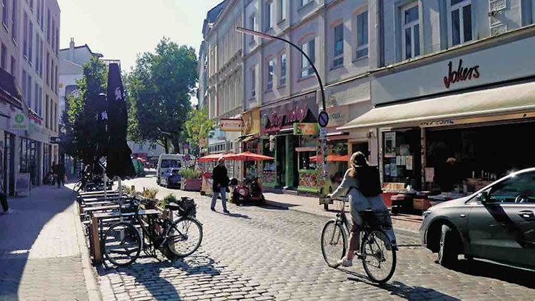  Ein Fahrrad fährt durch ein Quartier.