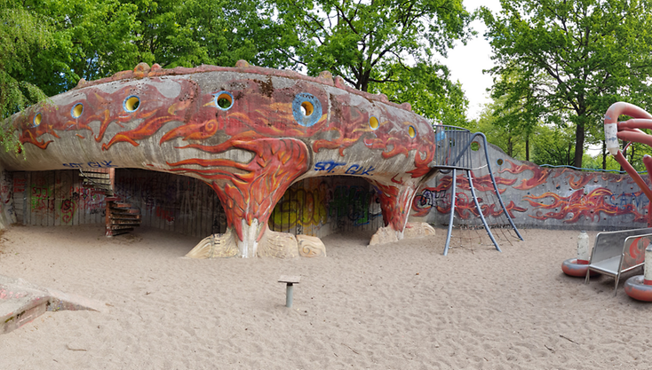 Eine Panorma-Aufnahme eines Spielplatzes mit einer Rutsche in Drachenform.