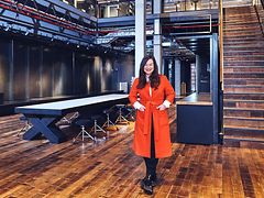  Frances Uckermann steht im roten Mantel im Design Zentrum Hamburg