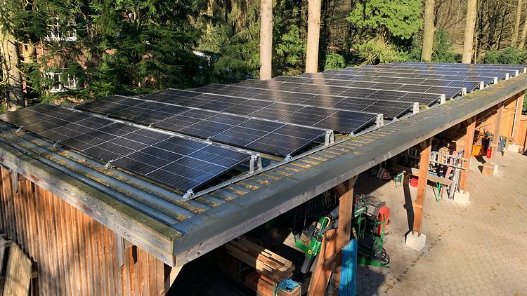  90m2 Solaranlage auf einem Schuppen mit Forstgeräten.