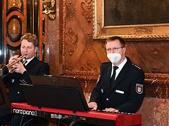  Links: Ein Mann an der Trompete, Rechts: Ein Mann am E-Klavier. Beide Männer tragen eine Uniform der Polizeiorchesters Hamburg.