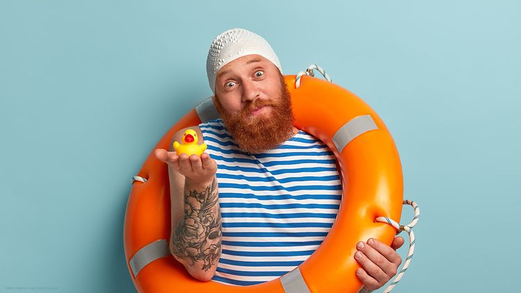  Mann mit orangem Schwimmreifen und Gummiente