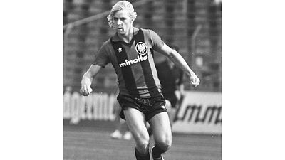  Norbert Nachtweih im Trikot von Eintracht Frankfurt auf dem Fußballplatz am Ball. 