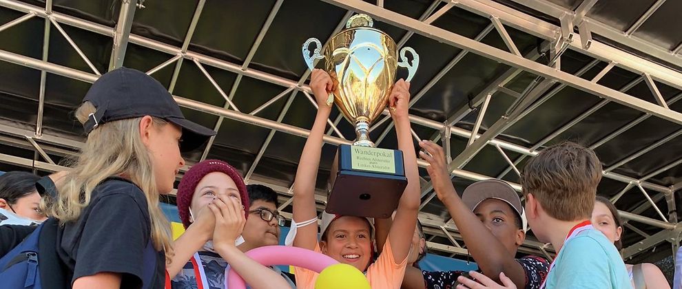 Siegerehrung Kinder halten Pokal in die Luft