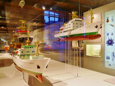  Modelle von Schiffen, die in einem Glaskasten ausgestellt sind.