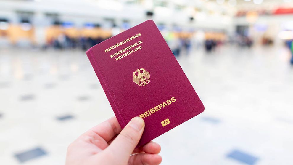  Eine Hand hält einen Reisepass der Bundesrepublik Deutschland in die Höhe.