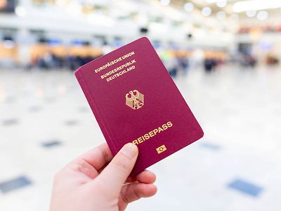  Eine Hand hält einen Reisepass der Bundesrepublik Deutschland in die Höhe.