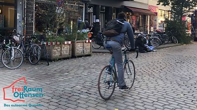  Ein Fahrradfahrer fährt auf Kopfsteinpflaster.