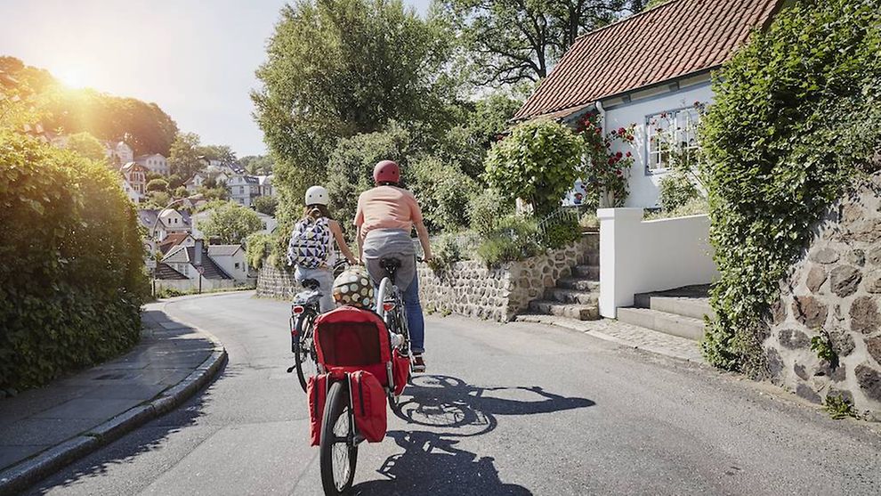 Eine Familie macht einen Fahrradausflug in einem Wohnviertel.
