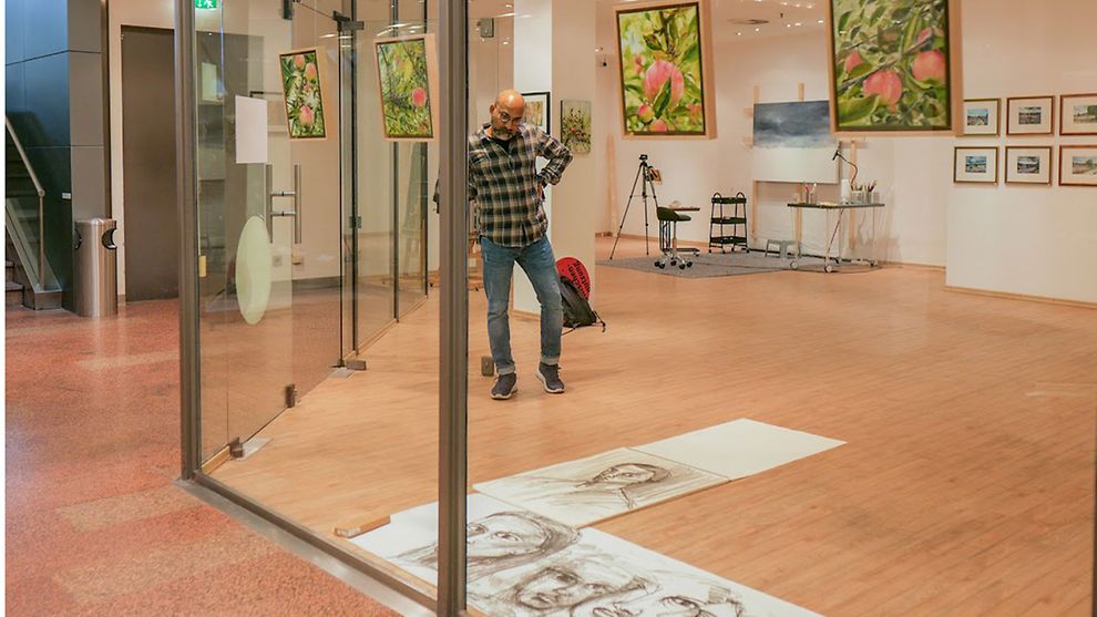 Der Künstler Arup J. Paul im Hamburger Hof auf der Ausstellungsfläche mt seinen Werken