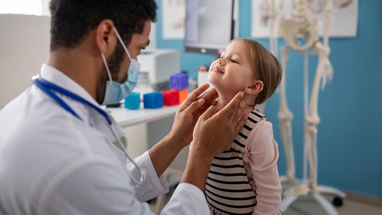  Ein Kinderarzt untersucht ein kleines Mädchen