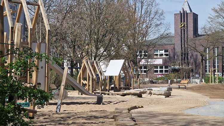  Ein neuer Spielplatz mit vielen Sandflächen und Holzkonstruktionen.