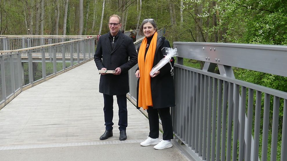Zwei Personen stehen auf der neu eröffneten Aluminiumbrücke.