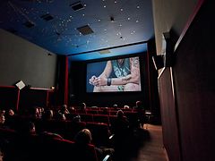  Es ist ein Kinosaal des 3001 Kinos zu sehen, auf der Leinwand läuft ein Film mit Untertiteln.