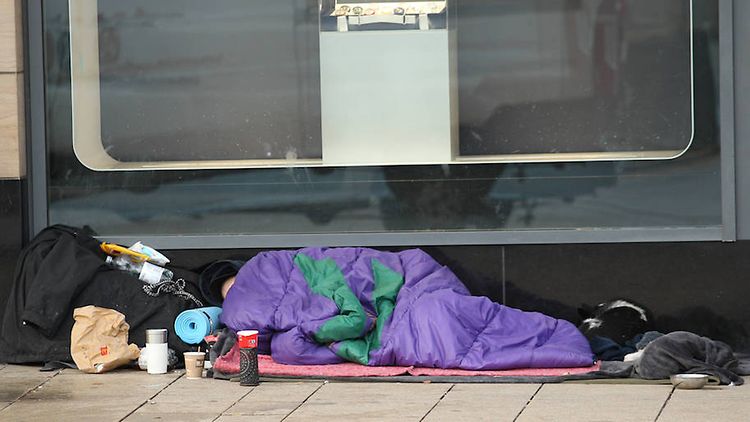  Ein Obdachloser liegt in einem Schlafsack vor einem Geschäft am Jungfernstieg in Hamburg.