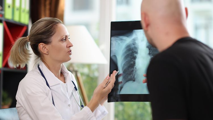  Eine Ärztin erklärt einem Patienten ein Röntgenbild