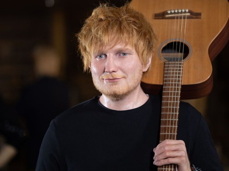  Wachsfigur von Ed Sheeran, der eine Gitarre auf der Schulter trägt.