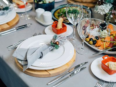  Auf einem festlich gedeckten Tisch steht ein Teller mit Antipasti und Lachs.