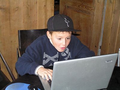  Ein Junge sitzt vor einem Notebook