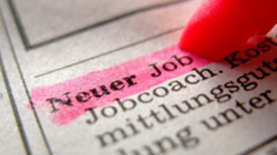  Textmarker markiert den Schriftzug "Neuer Job" in der Zeitung