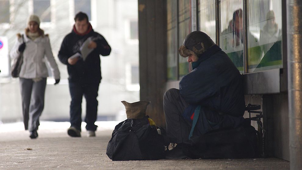 Ein Bettler sitzt auf dem Bürgersteig