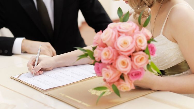  Angehendes Ehepaar unterzeichnet Papiere im Standesamt