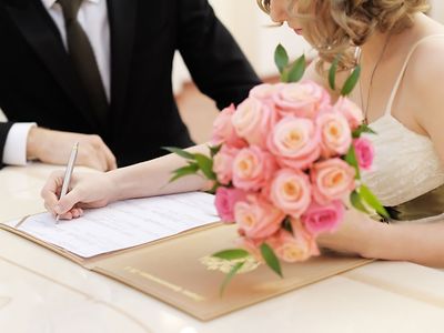  Angehendes Ehepaar unterzeichnet Papiere im Standesamt