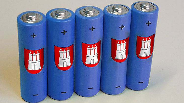  Fünf kleine blaue Batterien mit Hamburg-Symbol auf Schreibtisch